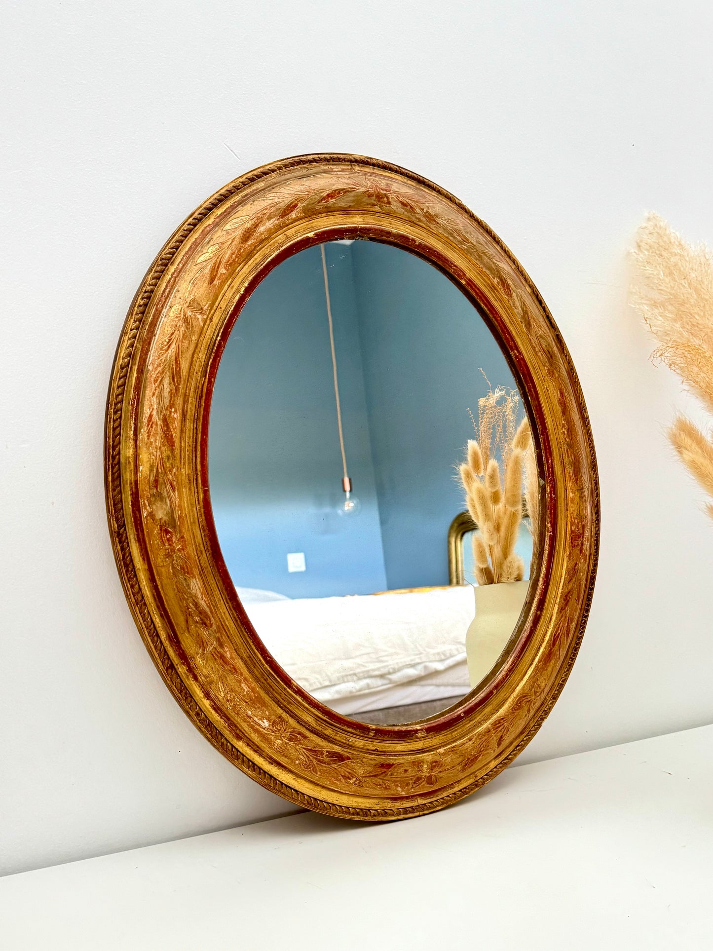 Miroir ancien ovale doré à la feuille d’or